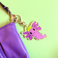 Purple axolotl keychain with a green frog hat