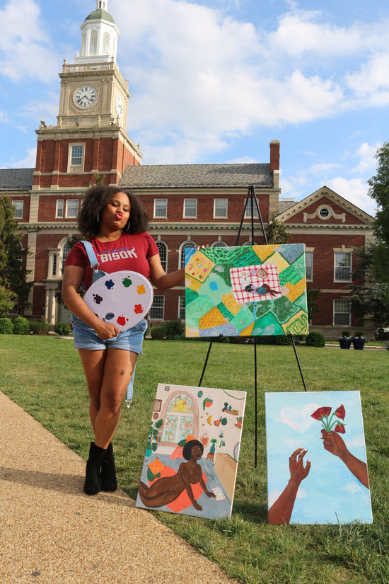 Image of artist in front of Howard University's Founders Library with 3 paintings.